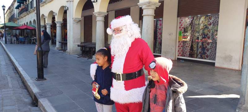 Ruso Oaxaqueño se viste de Santa Claus y regala juguetes a niños en el zócalo de Oaxaca